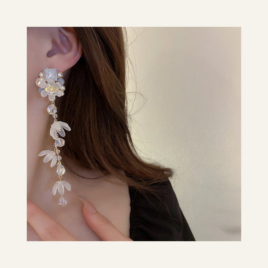 Blue Pearl & Crystal Floral Tassel Earrings in blue and pearl white, close-up worn on the ear