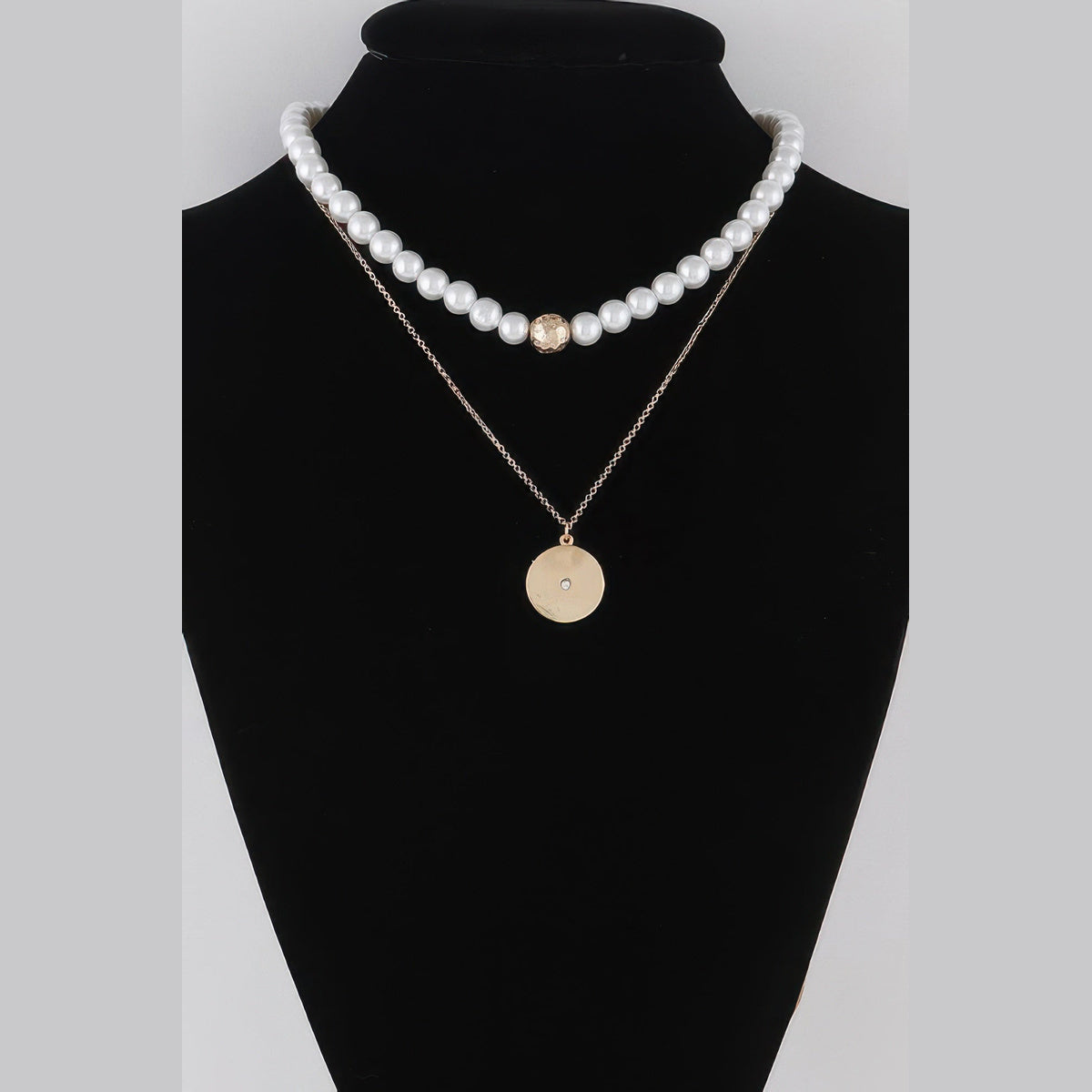 Pearl-Effect & Disc Layered Necklace in gold and cream, displayed on a necklace bust