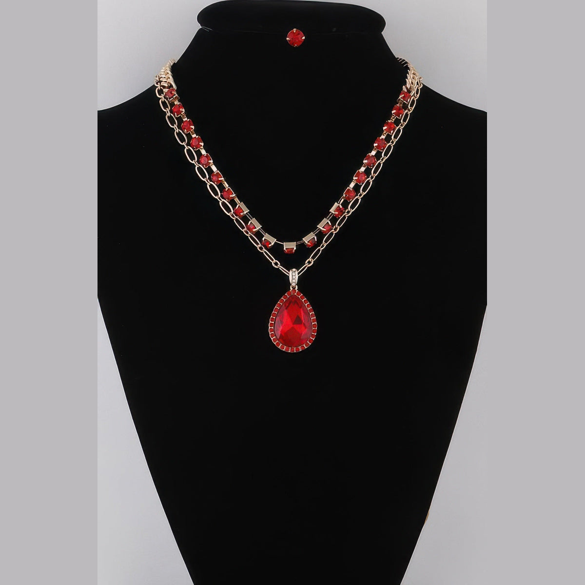 Jeweled Teardrop Layered Necklace in gold with red stones, displayed on a necklace bust