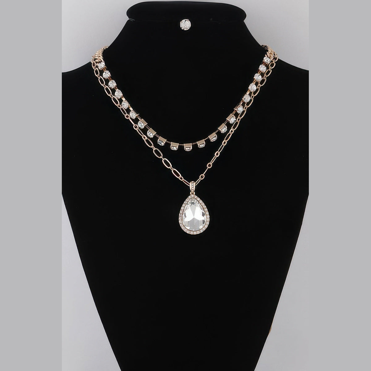Jeweled Teardrop Layered Necklace in gold with clear stones, displayed on a necklace bust