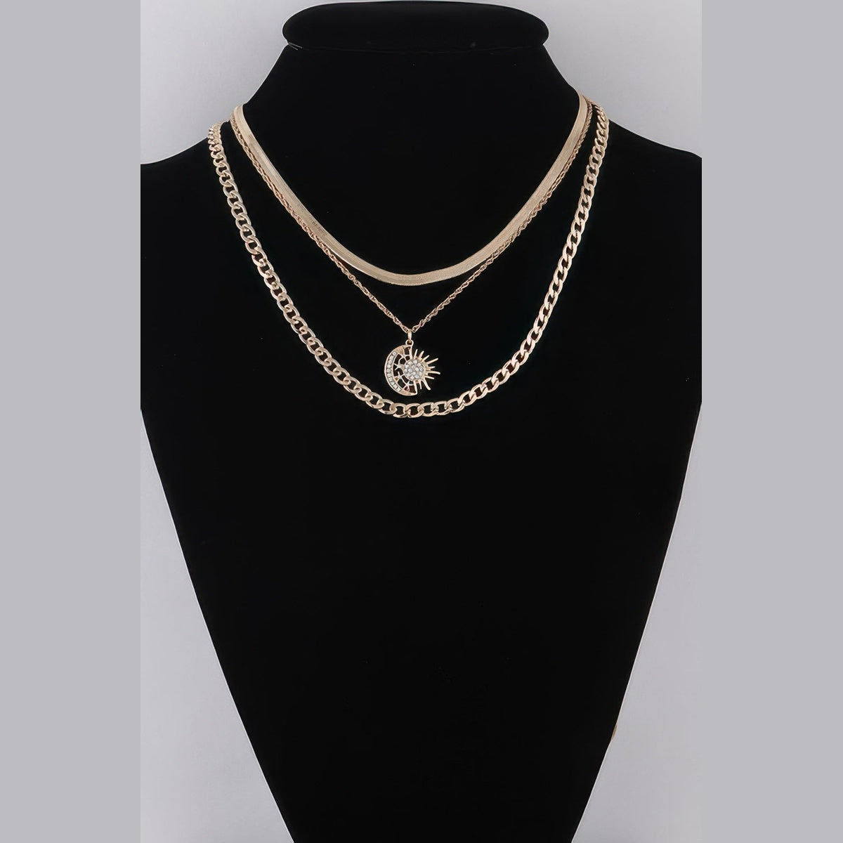 Sun & Moon Layered Necklace in gold with clear stones, displayed on a necklace bust