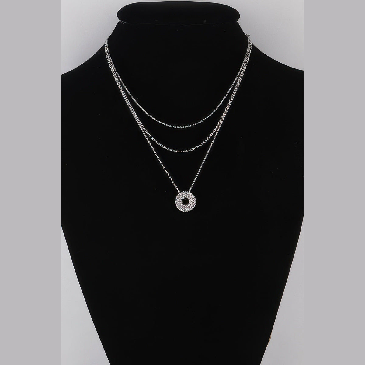 Jeweled Circle Layered Necklace in silver with clear stones, displayed on a necklace bust
