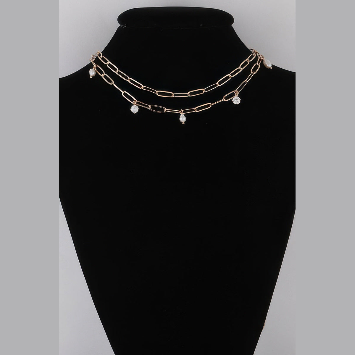 Pearl-Effect & Stone Paperclip Necklace in gold and cream, displayed on a necklace bust