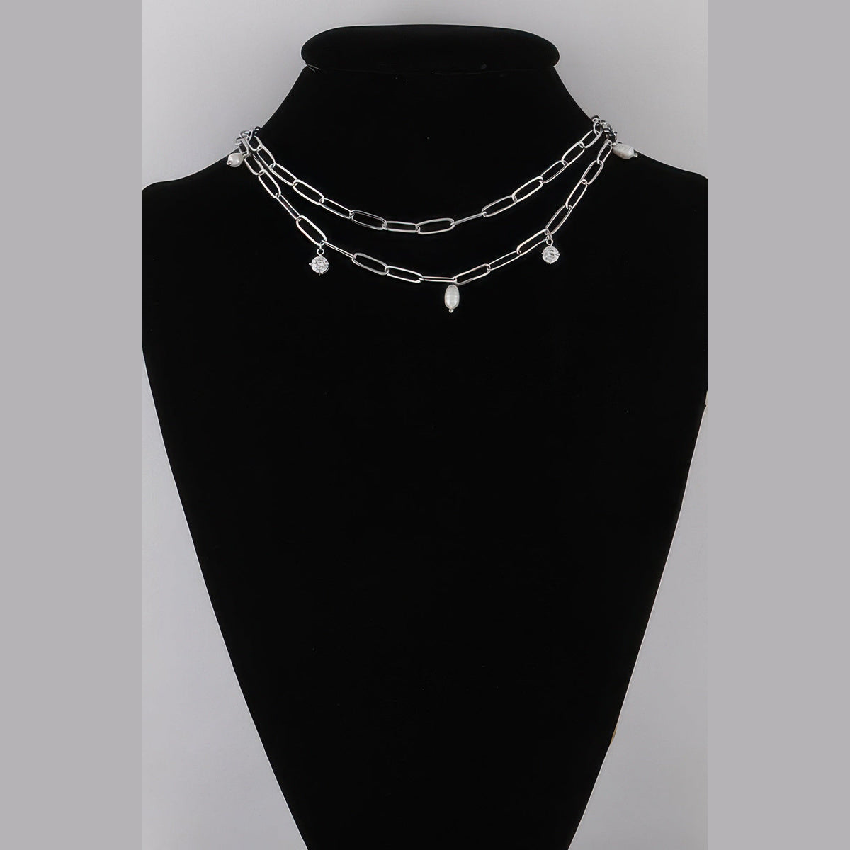 Pearl-Effect & Stone Paperclip Necklace in silver and cream, displayed on a necklace bust