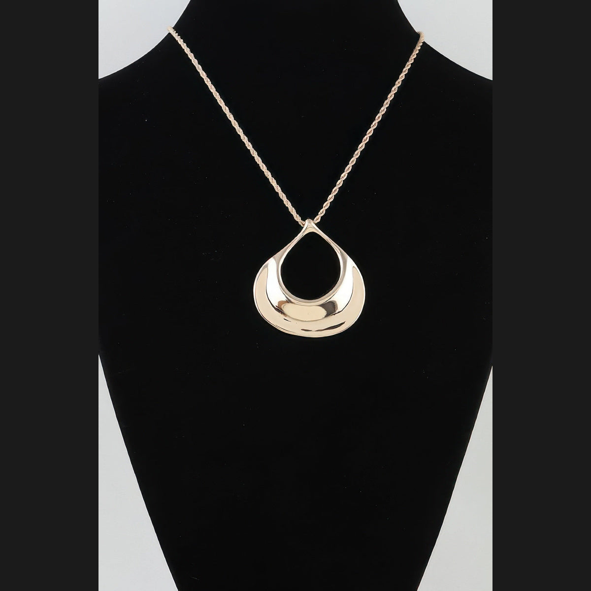 Sculptural Ripple Pendant Necklace in gold, displayed on a necklace bust