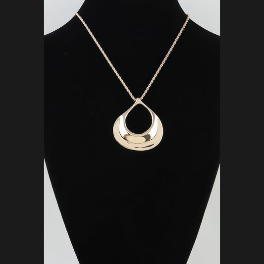 Sculptural Ripple Pendant Necklace in gold, displayed on a necklace bust