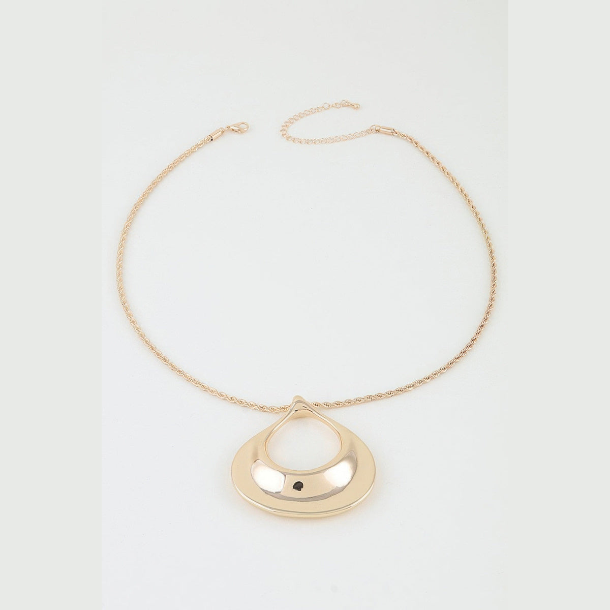 Sculptural Ripple Pendant Necklace in gold, flat lay