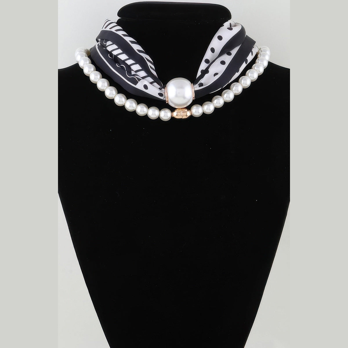 Scarf & Pearl-Effect Statement Necklace in black and white, displayed on a necklace bust