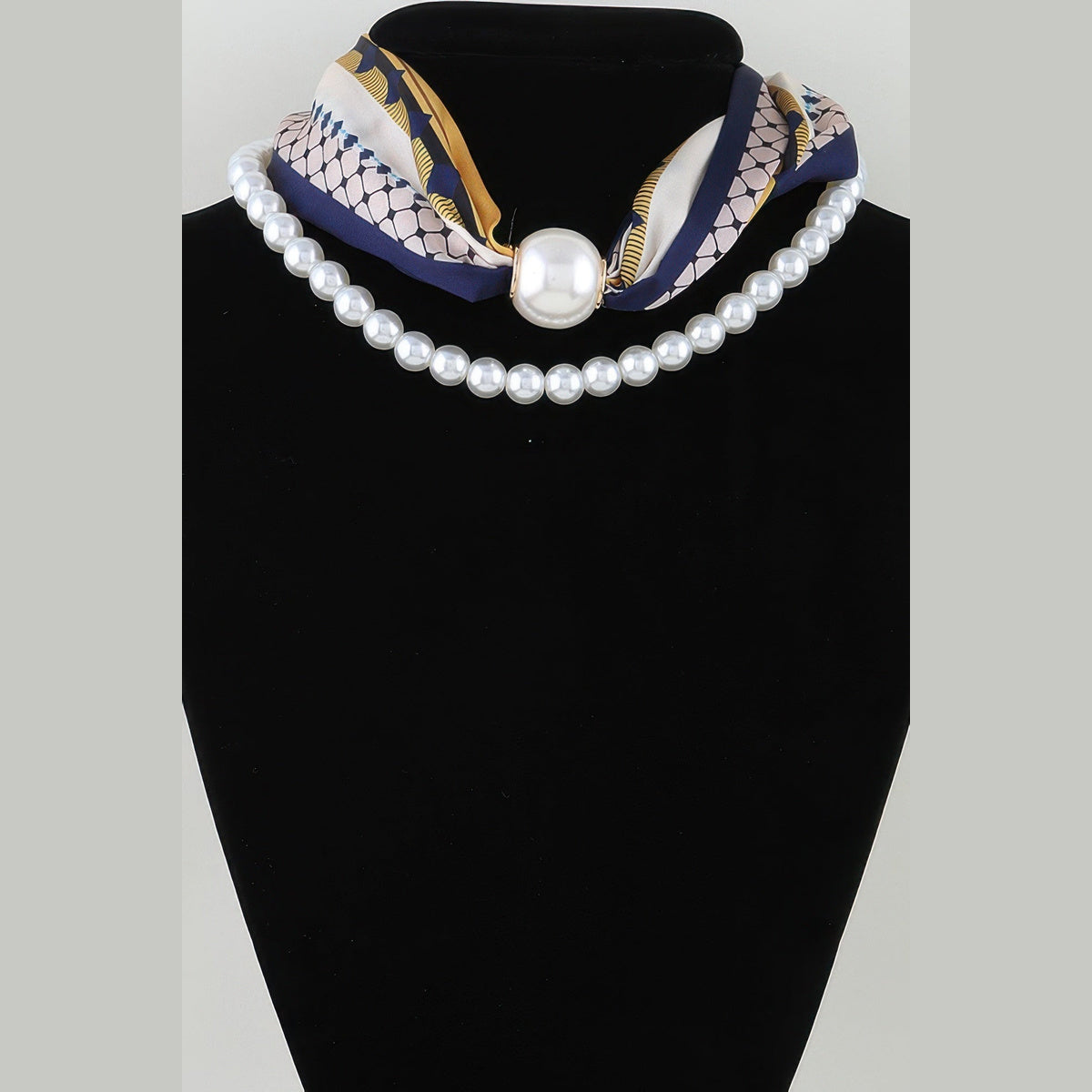 Scarf & Pearl-Effect Statement Necklace in yellow and navy, displayed on a necklace bust