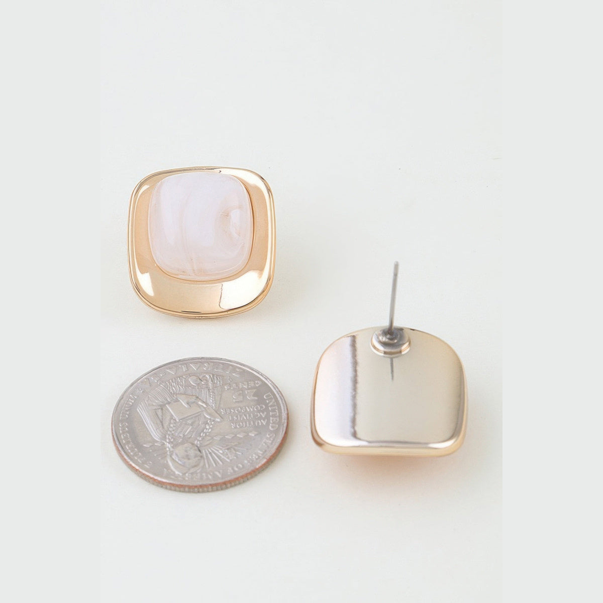 Polished Marbled Stone Stud Earrings in gold and ivory, front and reverse views beside a coin for scale