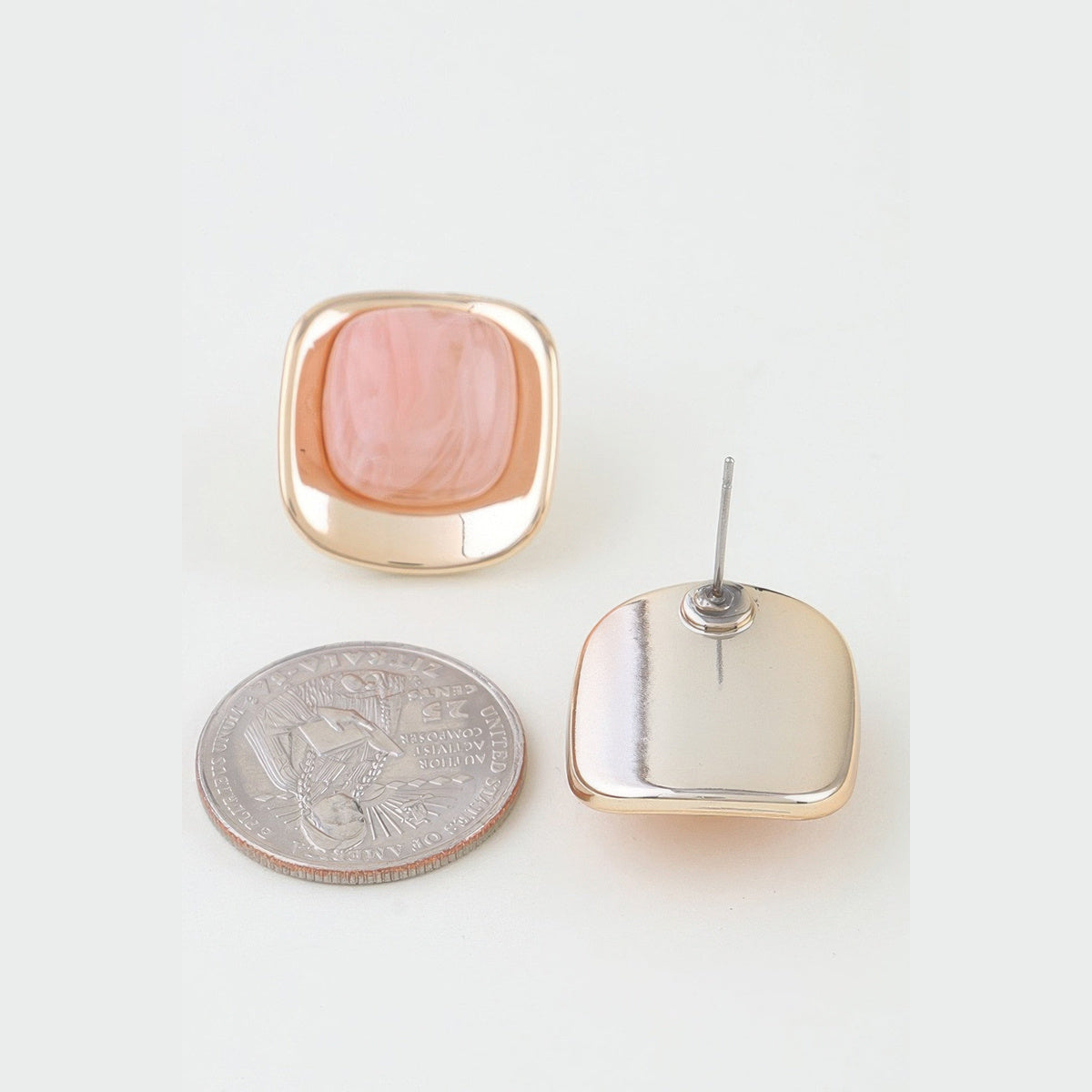 Polished Marbled Stone Stud Earrings in gold and pink, front and reverse views beside a coin for scale