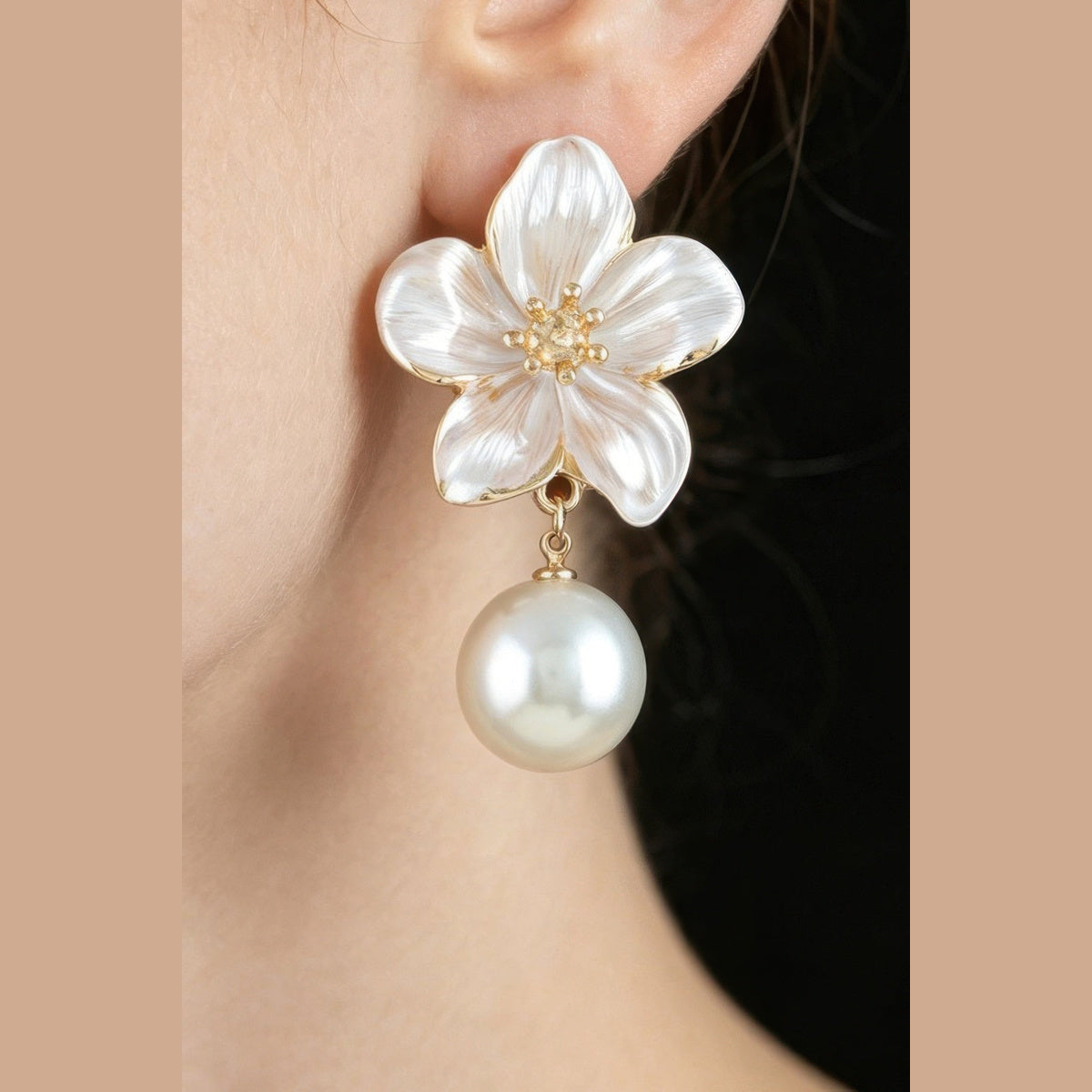 Pearl-Effect Flower Drop Earrings in gold and pearl white, close-up worn on the ear