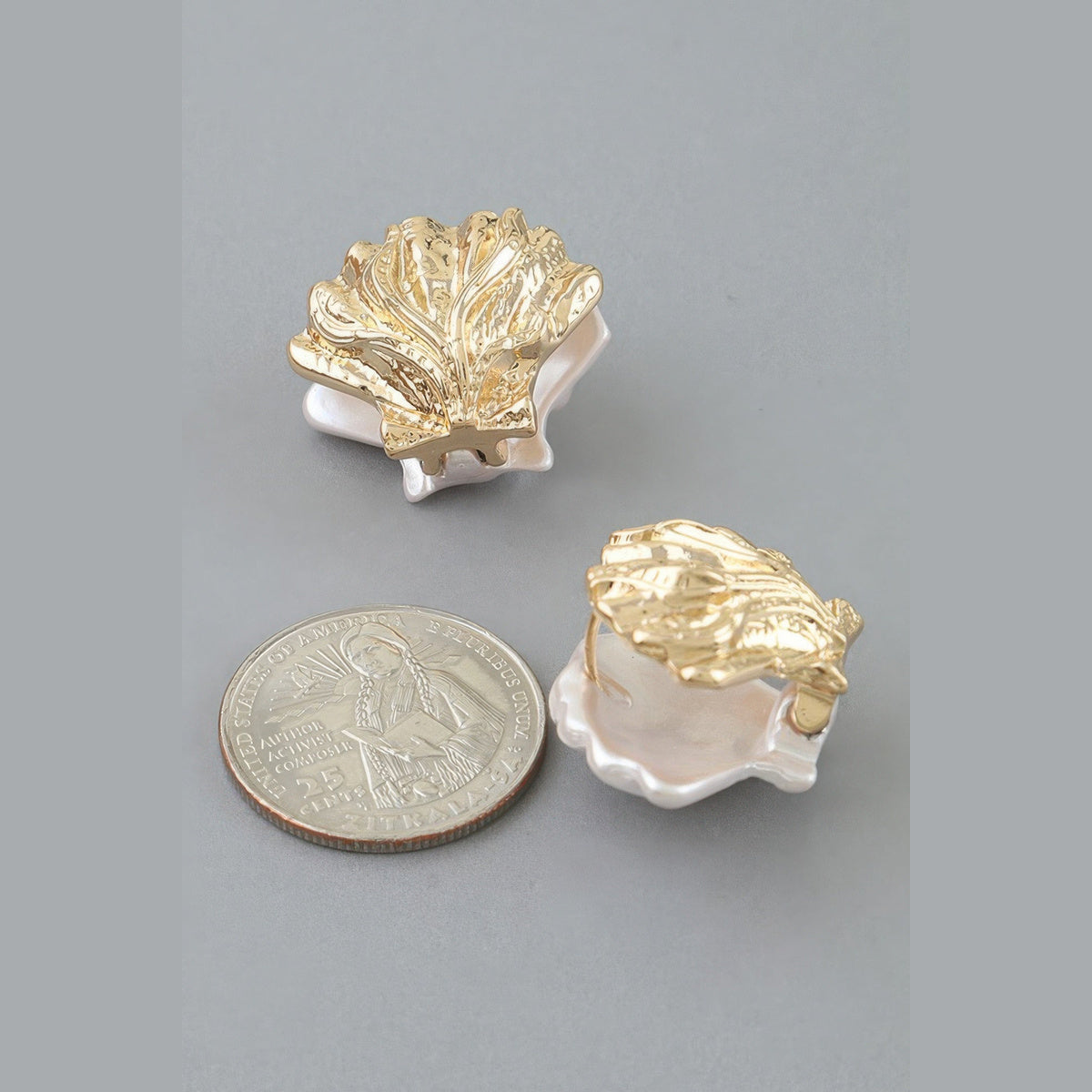 Two-Tone Clamshell Earrings in gold and pearl white, reverse view beside a coin for scale
