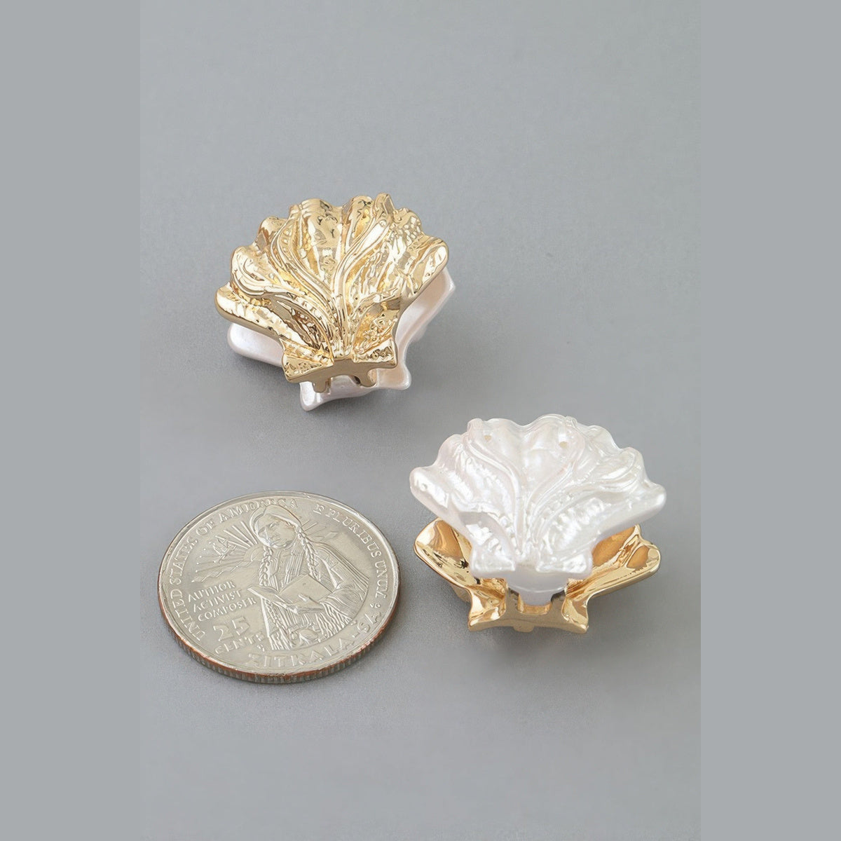 Two-Tone Clamshell Earrings in gold and pearl white, pearl-effect shell detail beside a coin for scale
