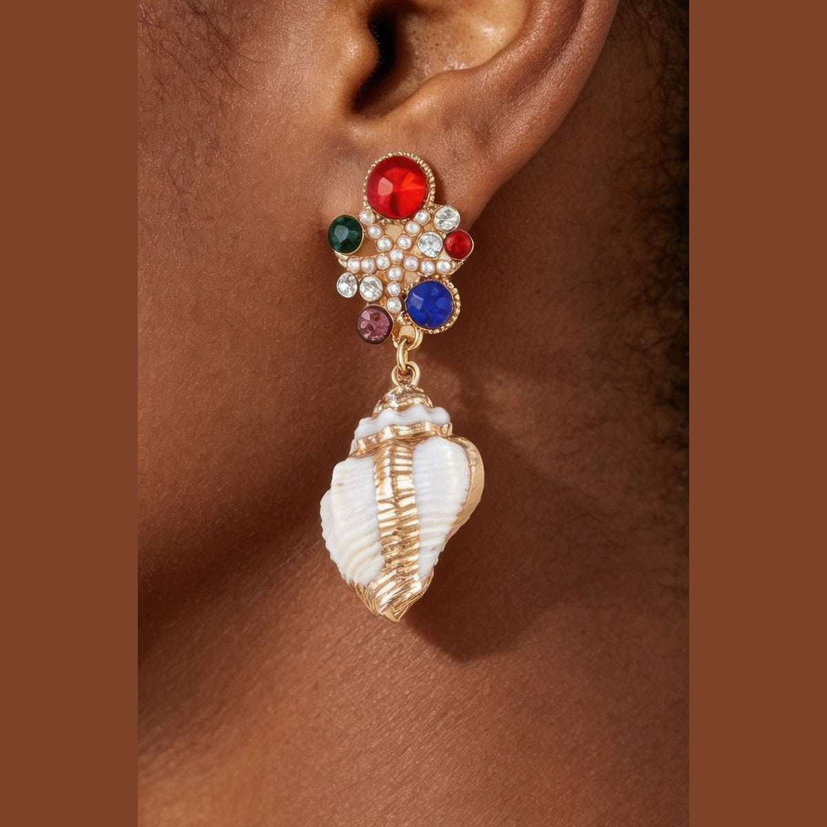 Jeweled Shell Statement Drop Earrings in gold with multicolor stones, styled on a model