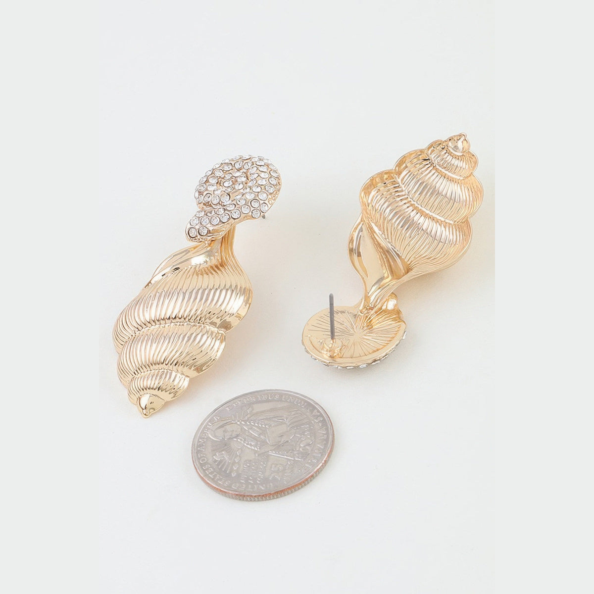 Jeweled Conch Shell Drop Earrings in gold with clear stones, reverse view beside a coin for scale