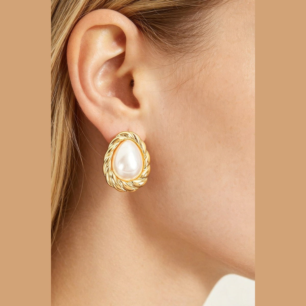 Twisted Frame Pearl-Effect Stud Earrings in gold and pearl white, styled on a model