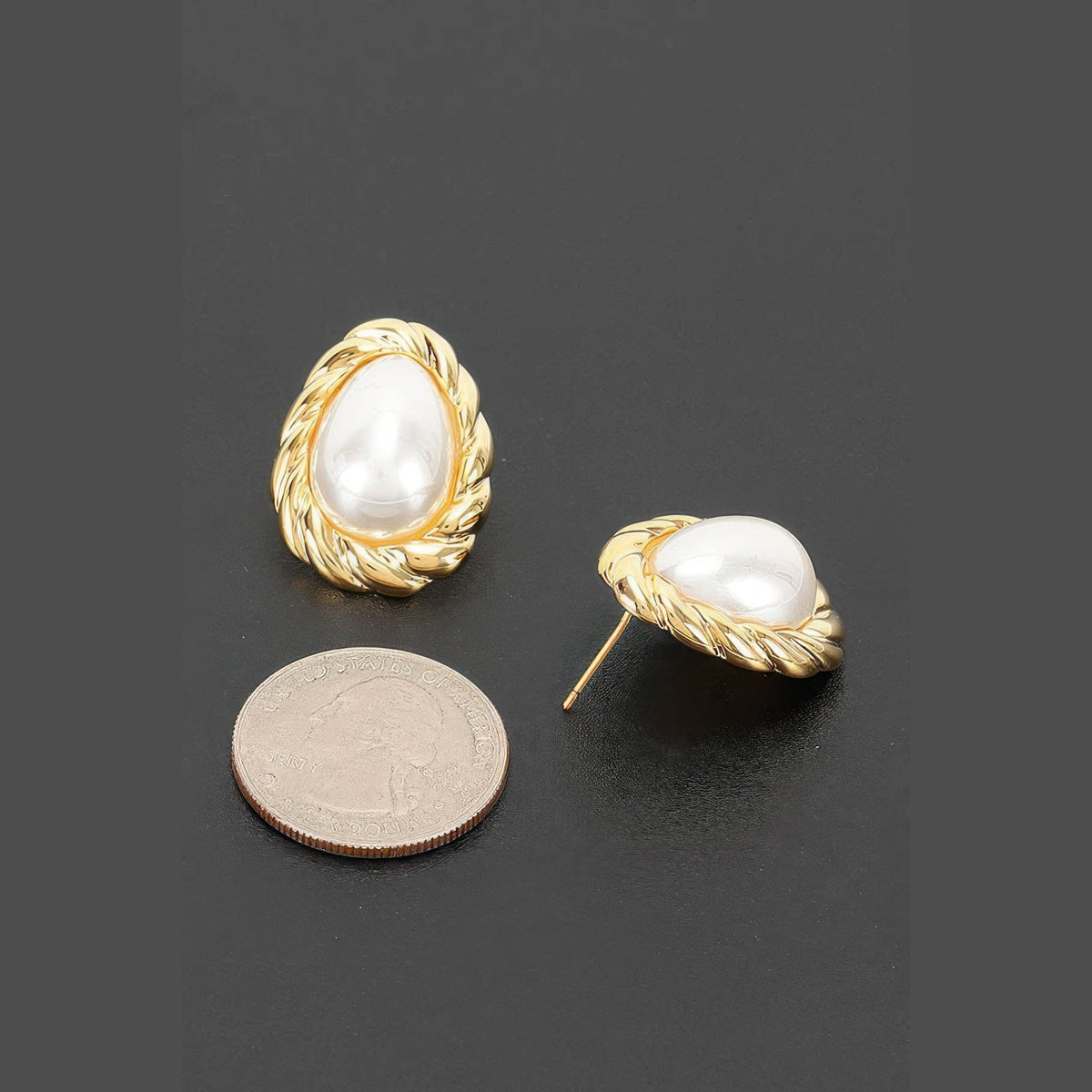 Twisted Frame Pearl-Effect Stud Earrings in gold and pearl white, earring posts and side profile beside a coin for scale