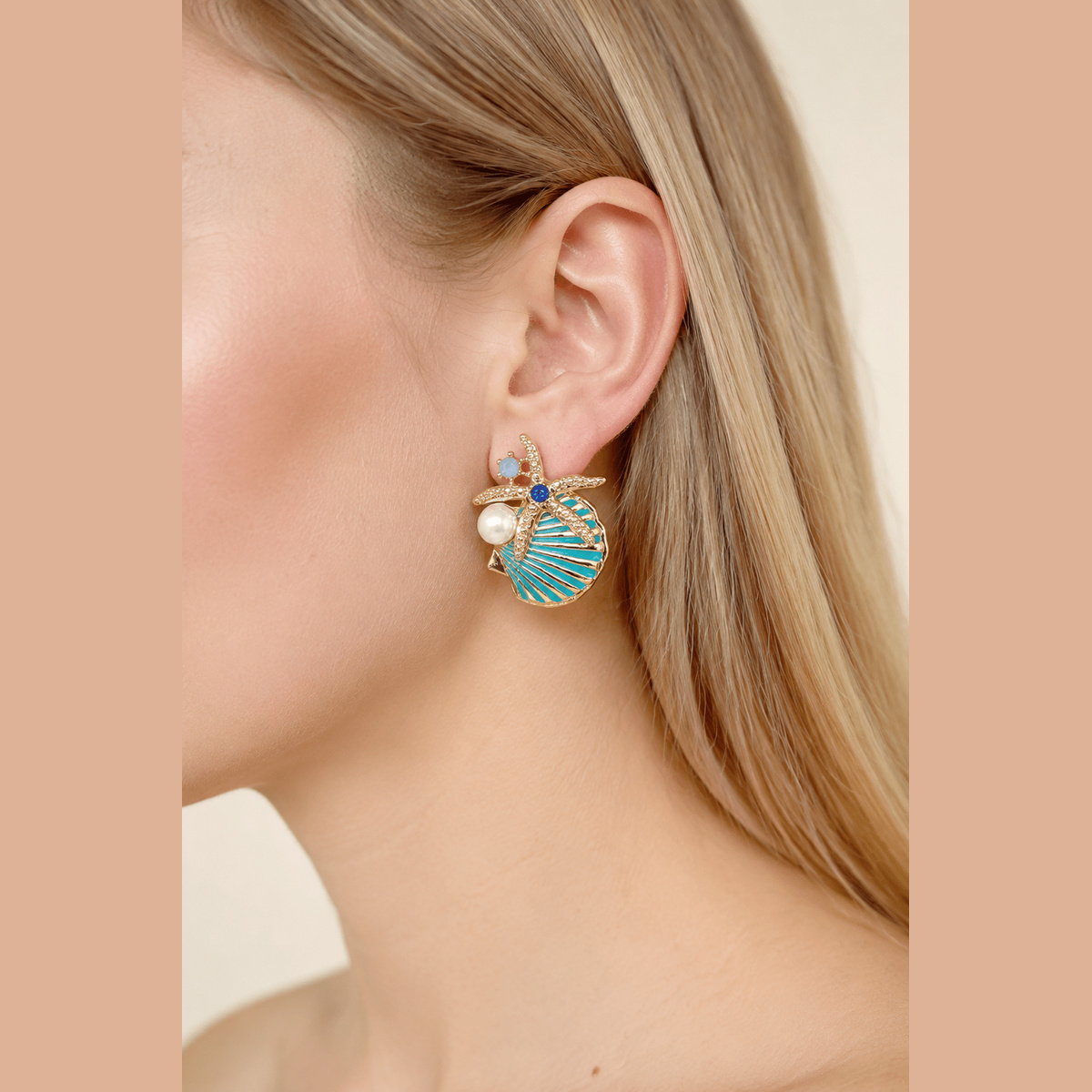 Starfish & Shell Statement Earrings in gold and aqua, worn on the ear