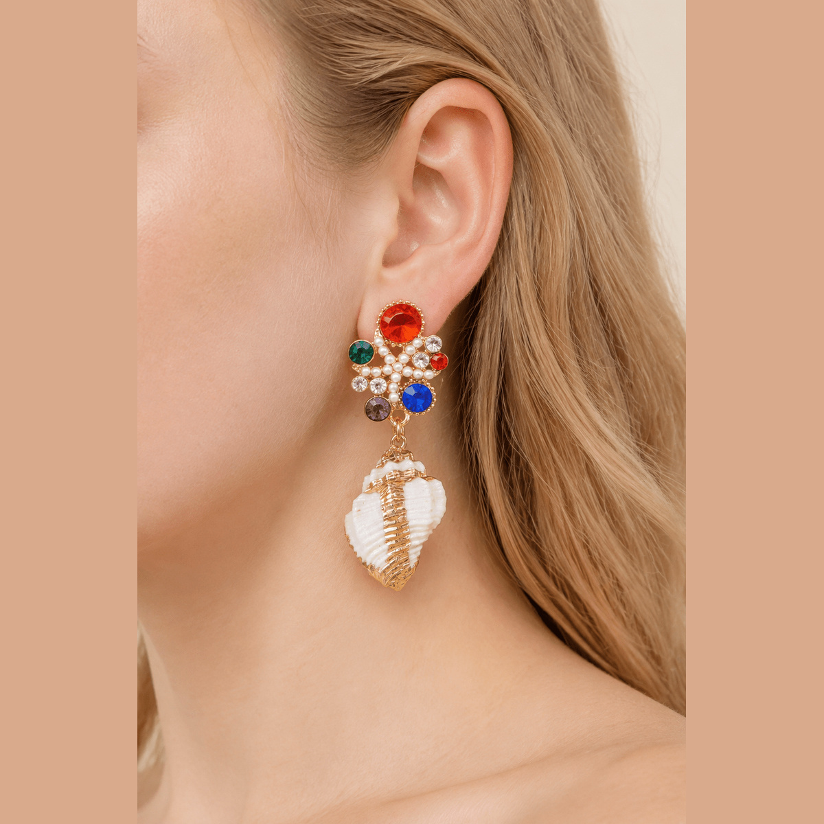 Jeweled Shell Statement Drop Earrings in gold with multicolor stones, worn on the ear