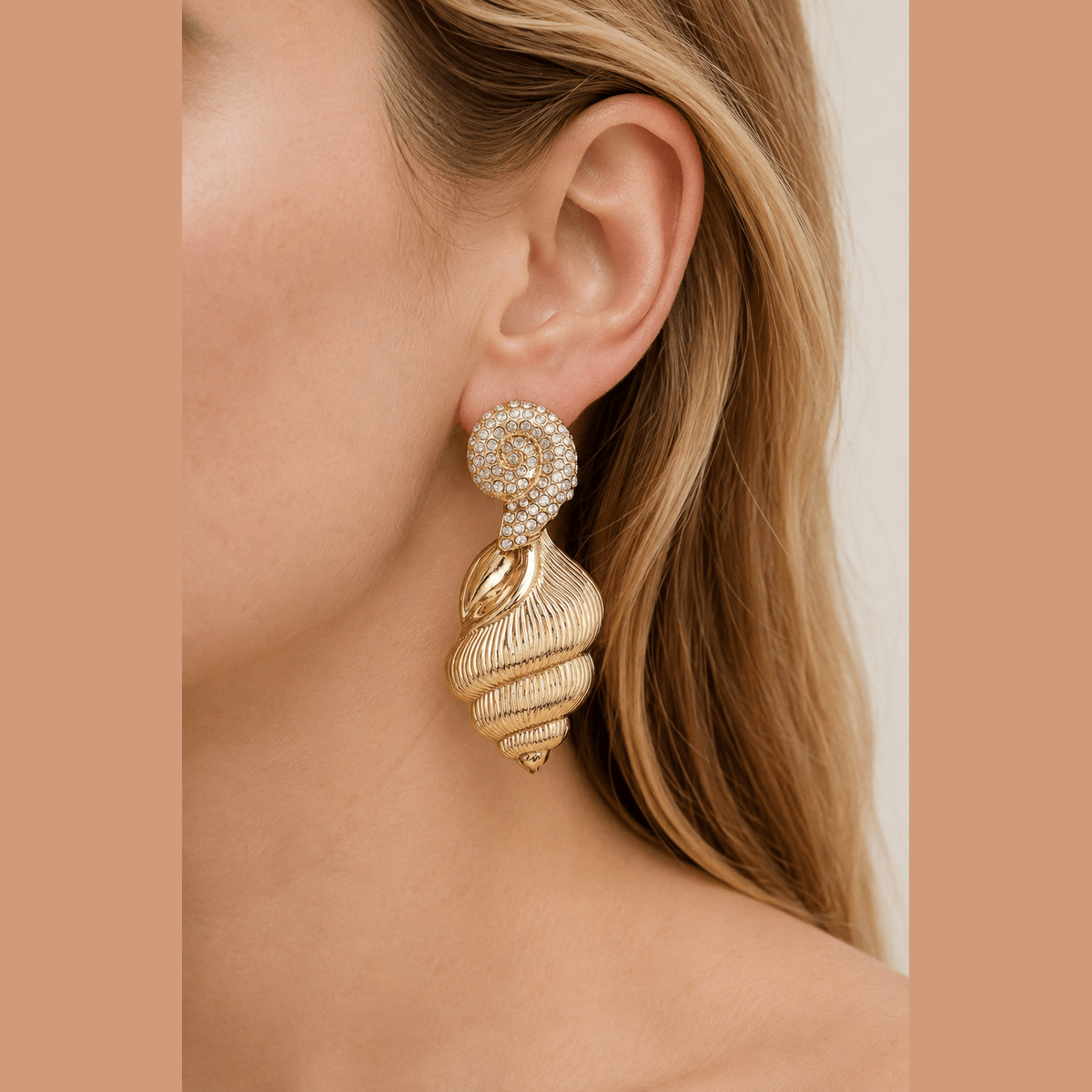 Jeweled Conch Shell Drop Earrings in gold with clear stones, worn on the ear