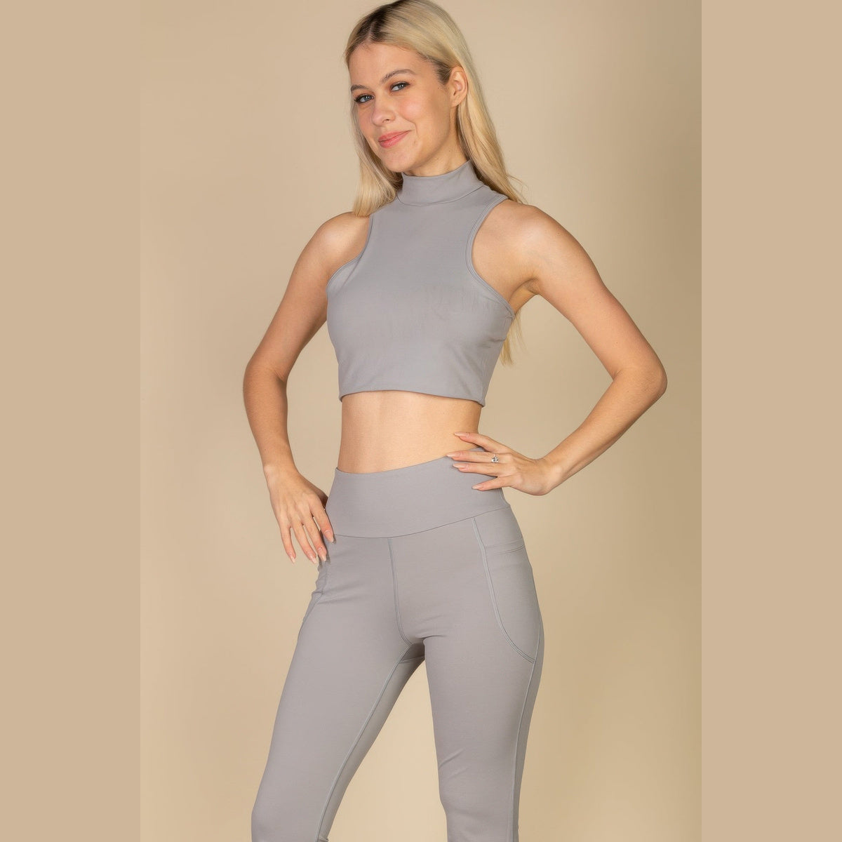 High-Neck Racerback Tank in cement gray, front view on a model