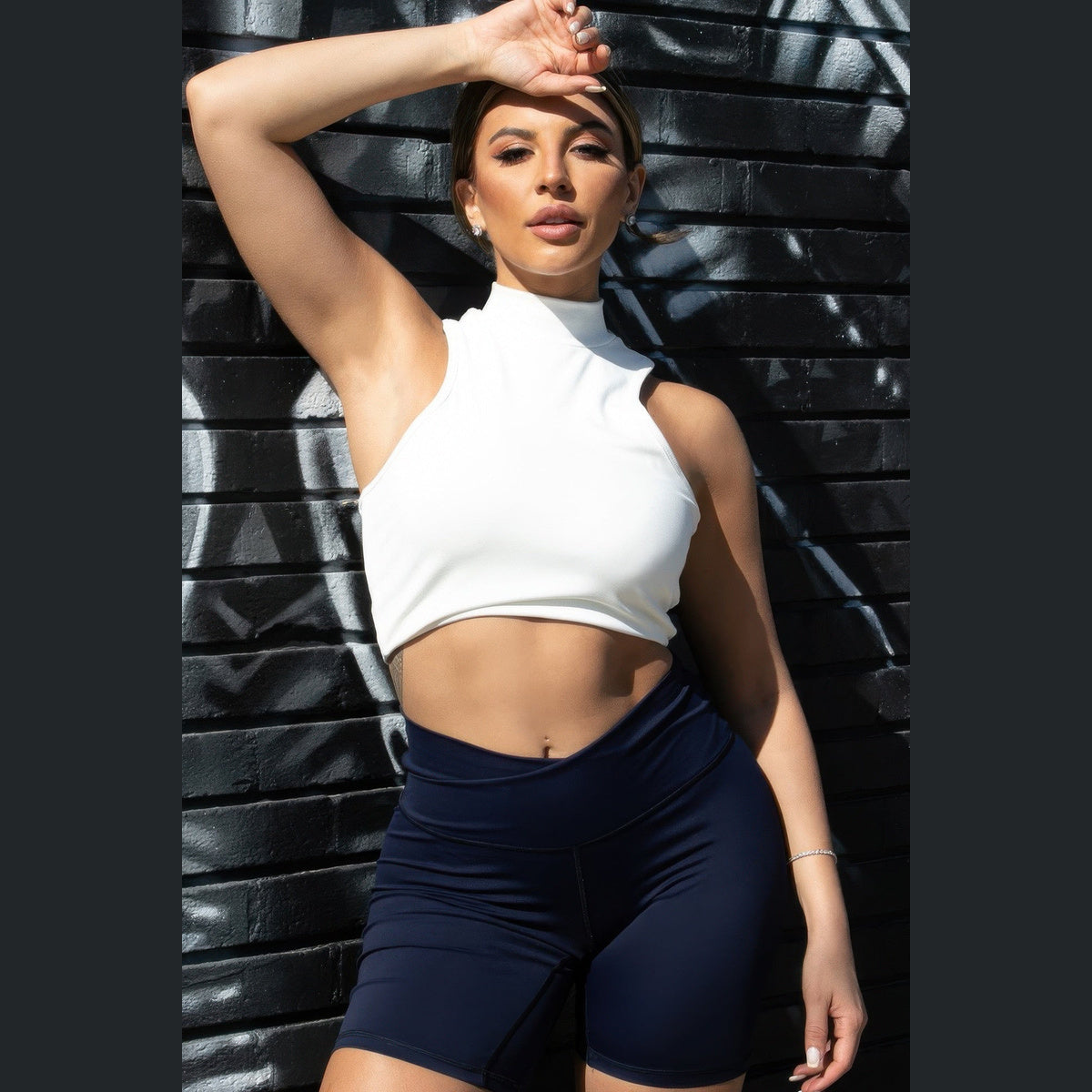 High-Neck Racerback Tank in white, front view on a model