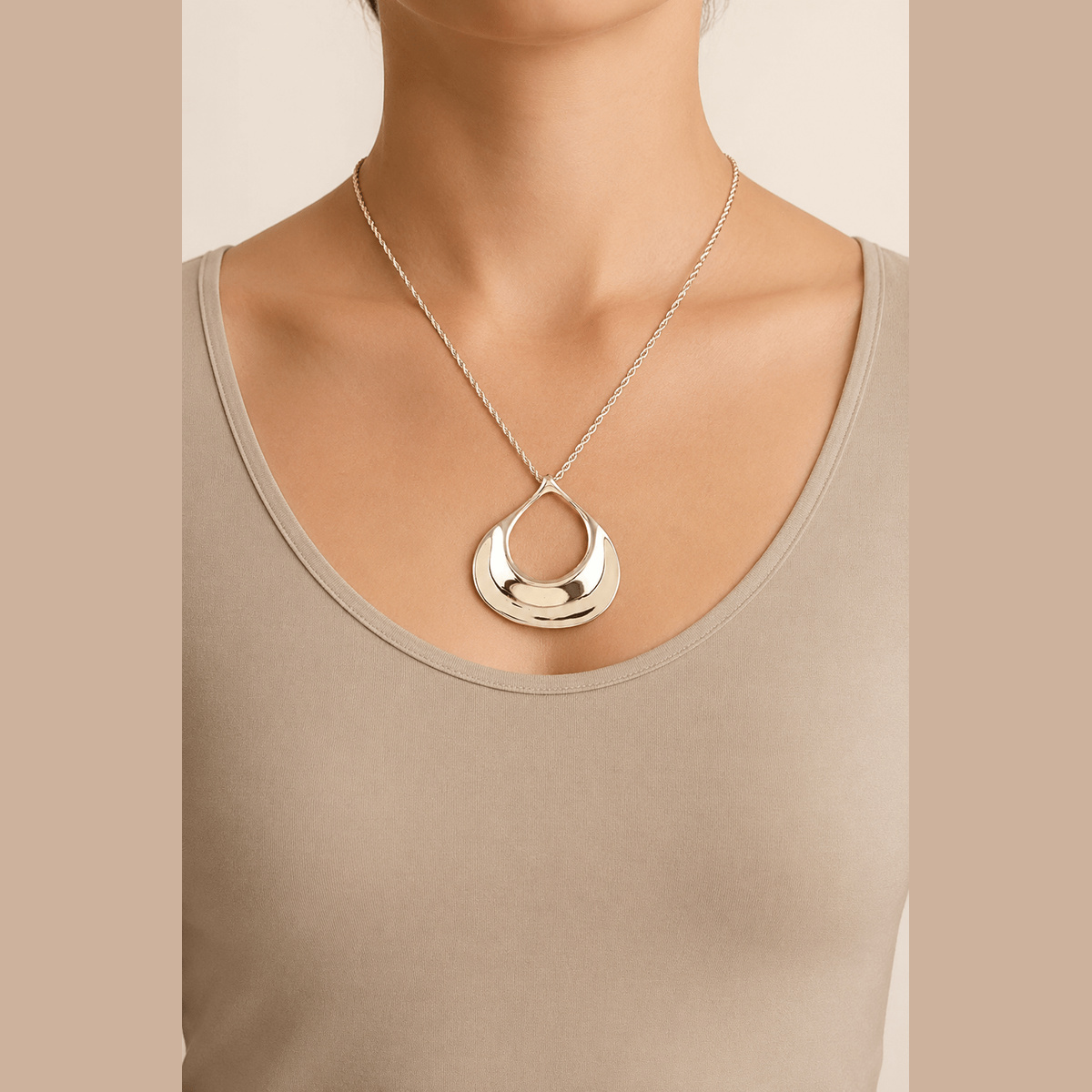 Sculptural Ripple Pendant Necklace in gold, worn around the neck