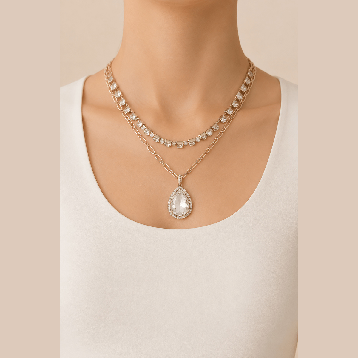 Jeweled Teardrop Layered Necklace in gold with clear stones, worn around the neck