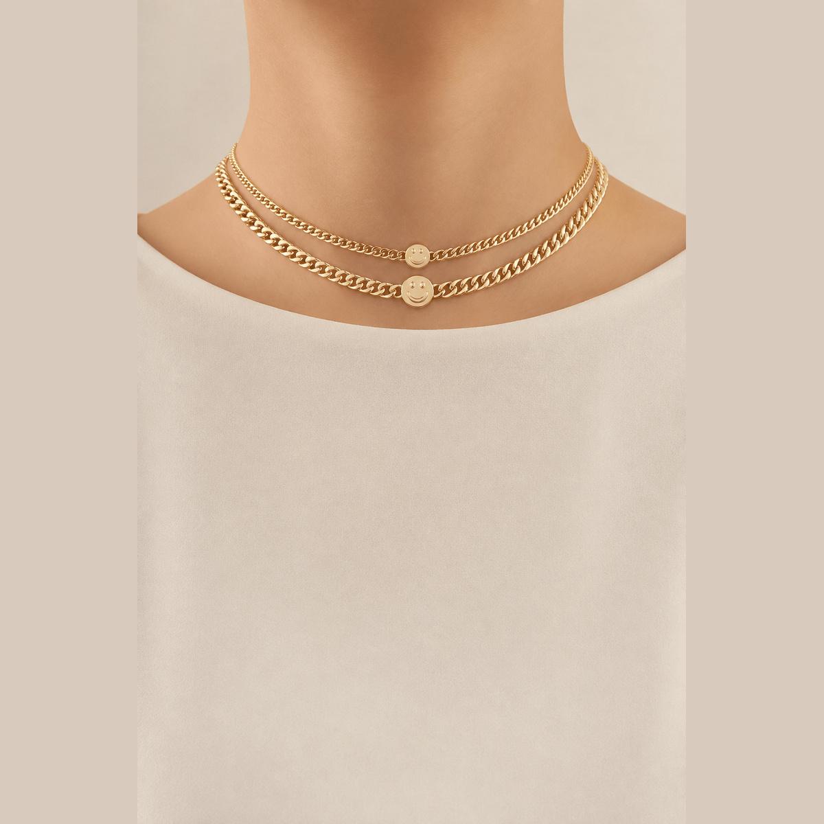 Smiley Disc Double-Chain Choker in gold, worn around the neck
