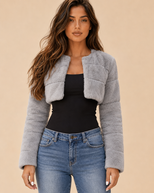 Woman wearing a collarless cropped faux-fur jacket on a warm beige studio background