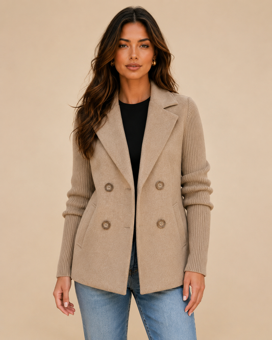 Woman wearing a double-breasted jacket with knit sleeves on a warm beige studio background