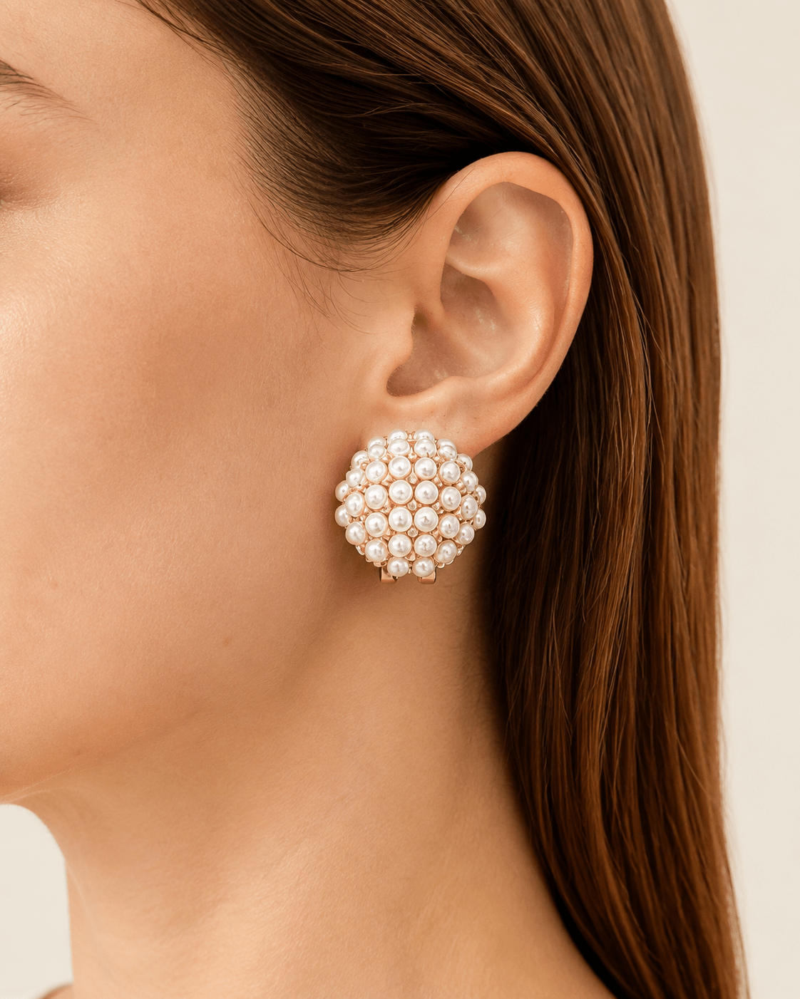 Close-up of a model wearing round pearl-effect cluster clip-on earrings