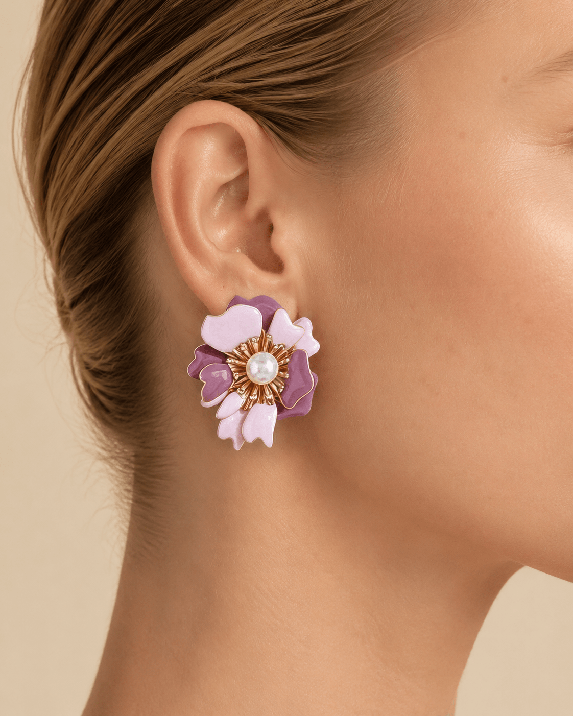 Close-up of a model wearing marbled blossom statement earrings with a pearl-effect center