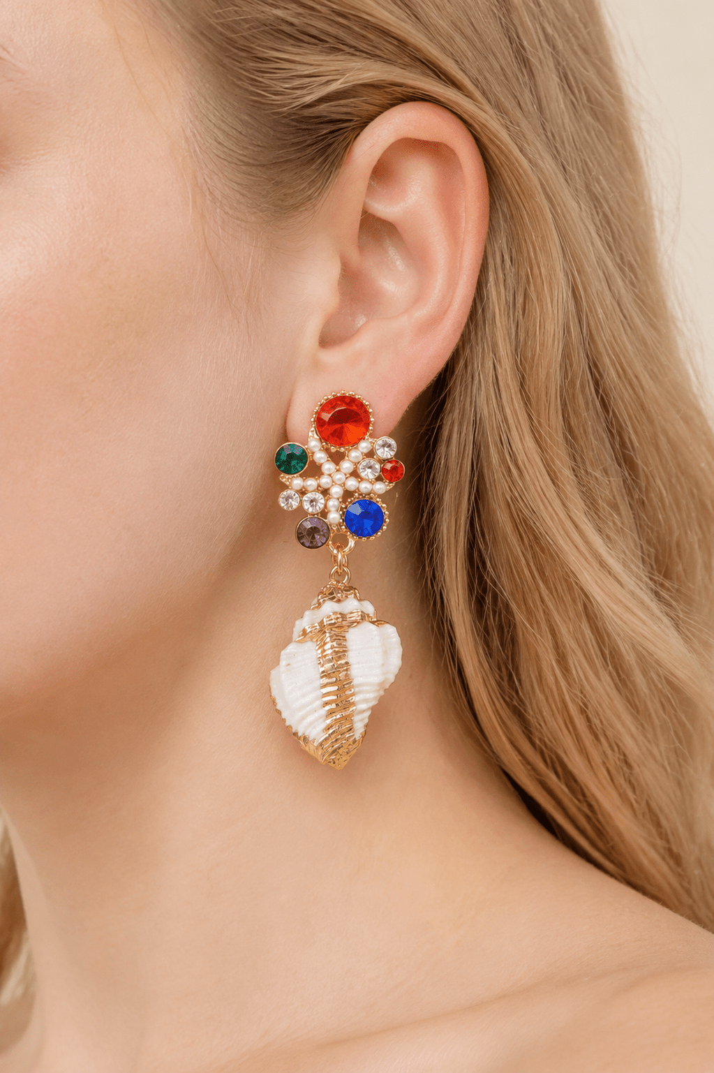 Close-up of a model wearing multicolor jeweled shell statement drop earrings