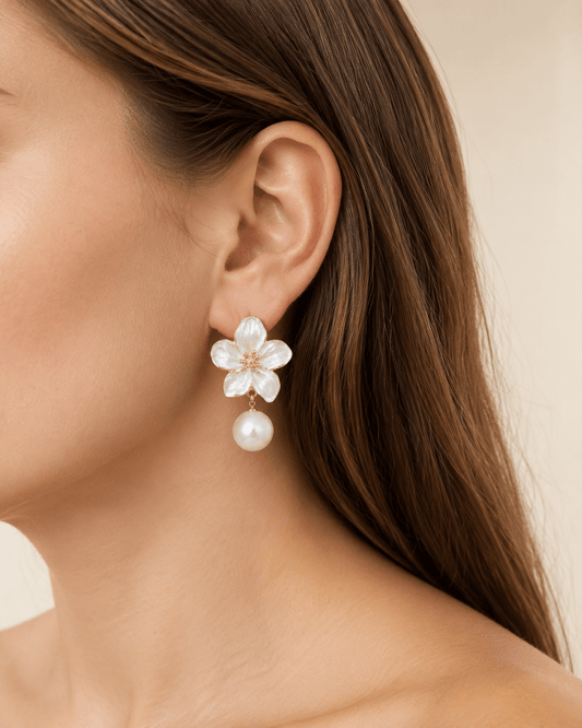 Close-up of a model wearing gold-tone pearl-effect flower drop earrings
