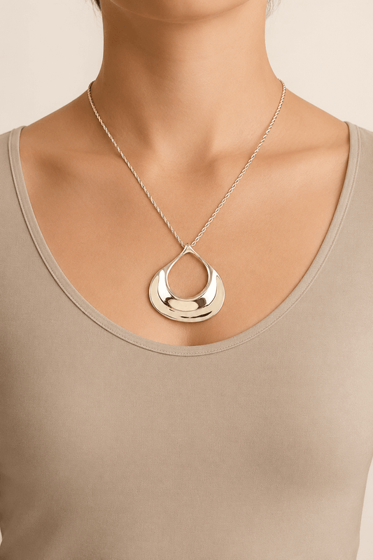 Sculptural ripple pendant necklace worn on a fair-light skin model