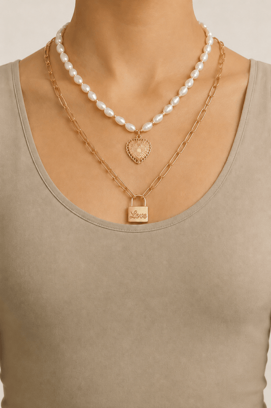 Pearl-effect heart and lock layered necklace worn on a fair-light skin model